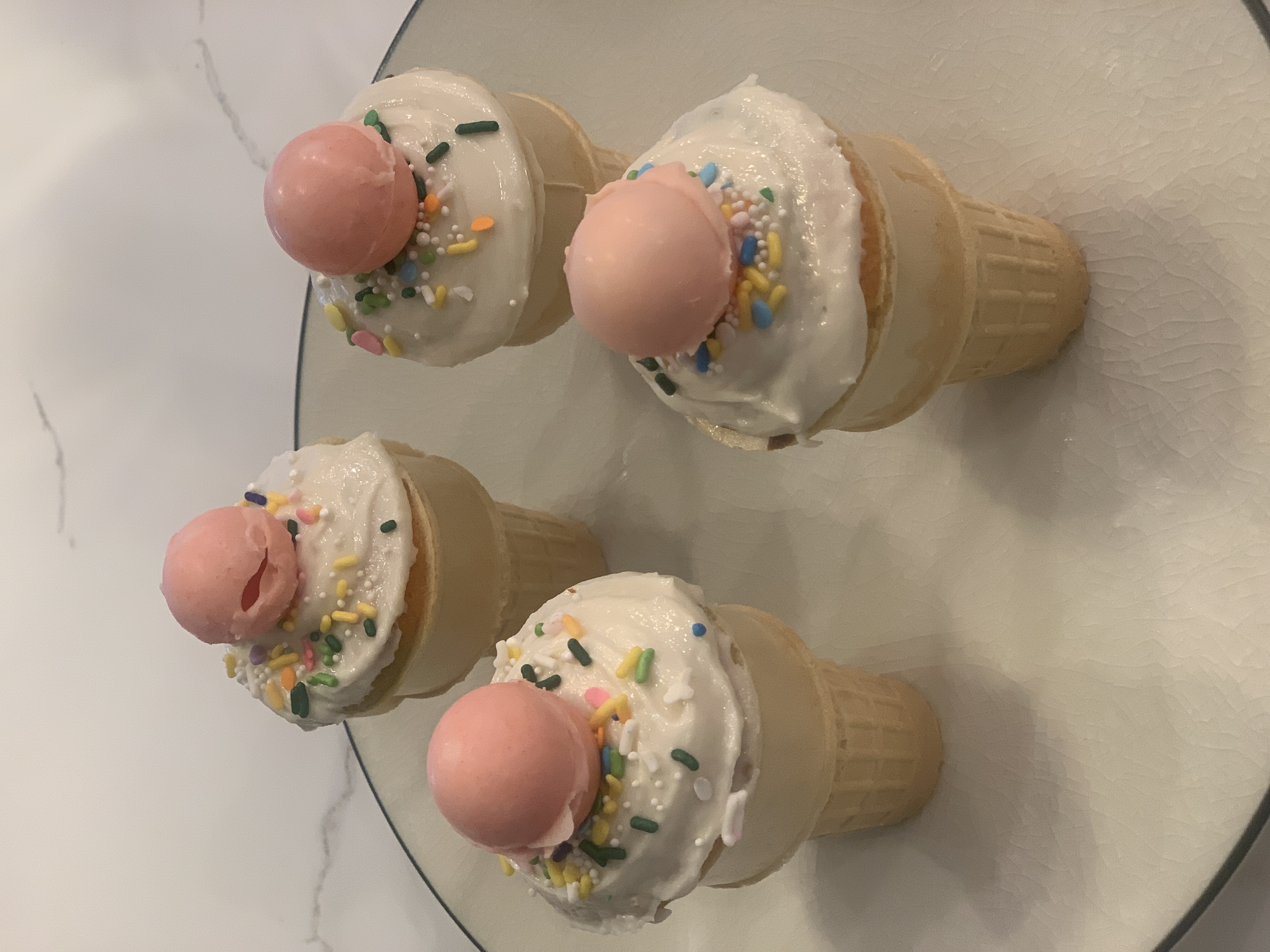 Cupcakes inside ice cream cake cones with frosting