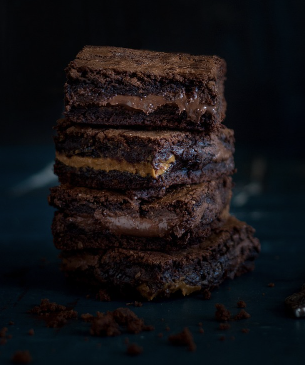 Gooey brownies stacked on top of each other.