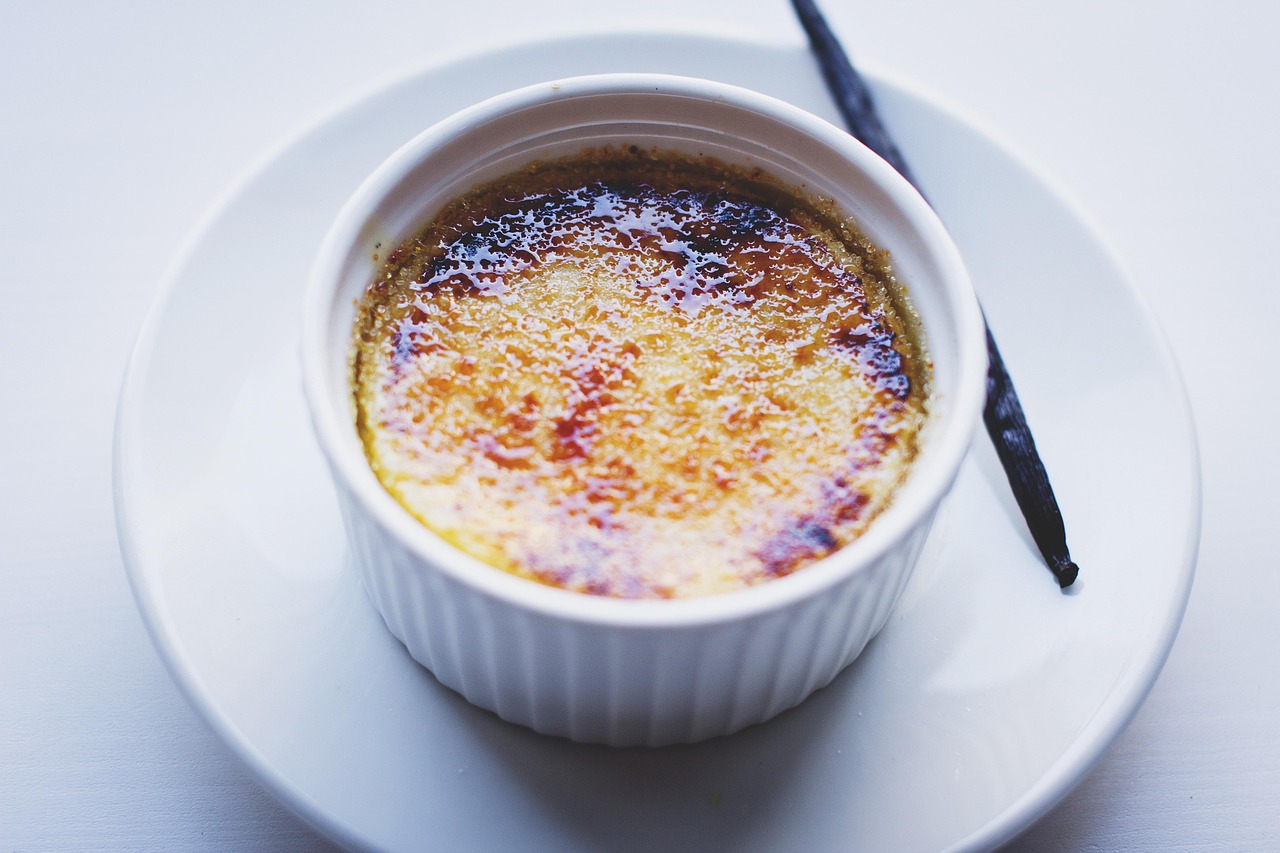 Crème brûlée in a white container on a plate.