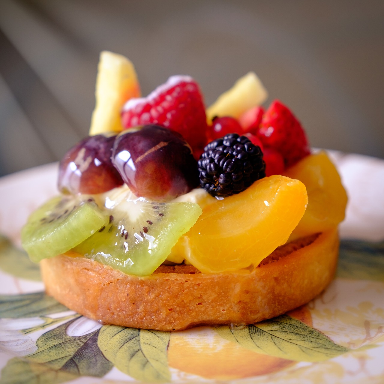 A fruit tart with a variety of fruits on top.