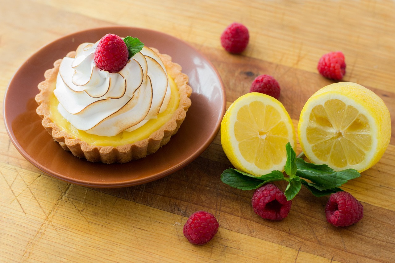 A lemon tart topped with meringue sitting on a plate.