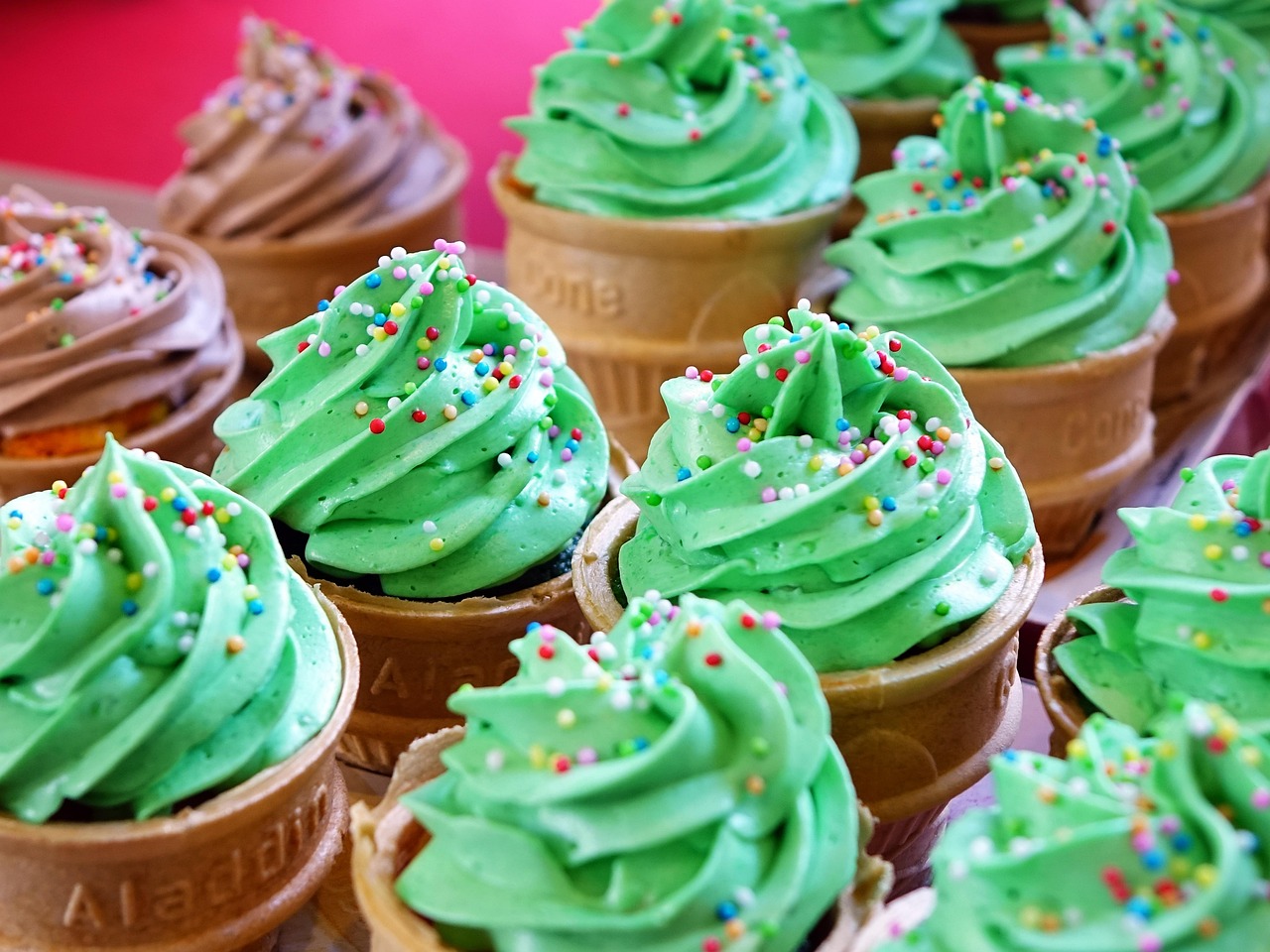 Ice cream cone cupcakes with bright green buttercream and sprinkles.